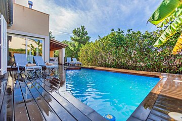 A house with a large swimming pool in front of it