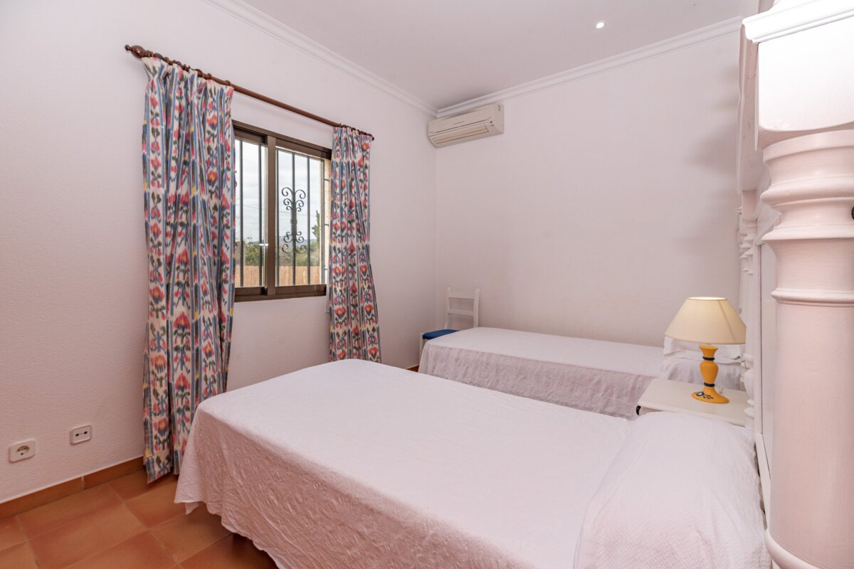 A bedroom with two beds and a lamp