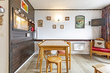 A room with a table and chairs and a sign that says alpes