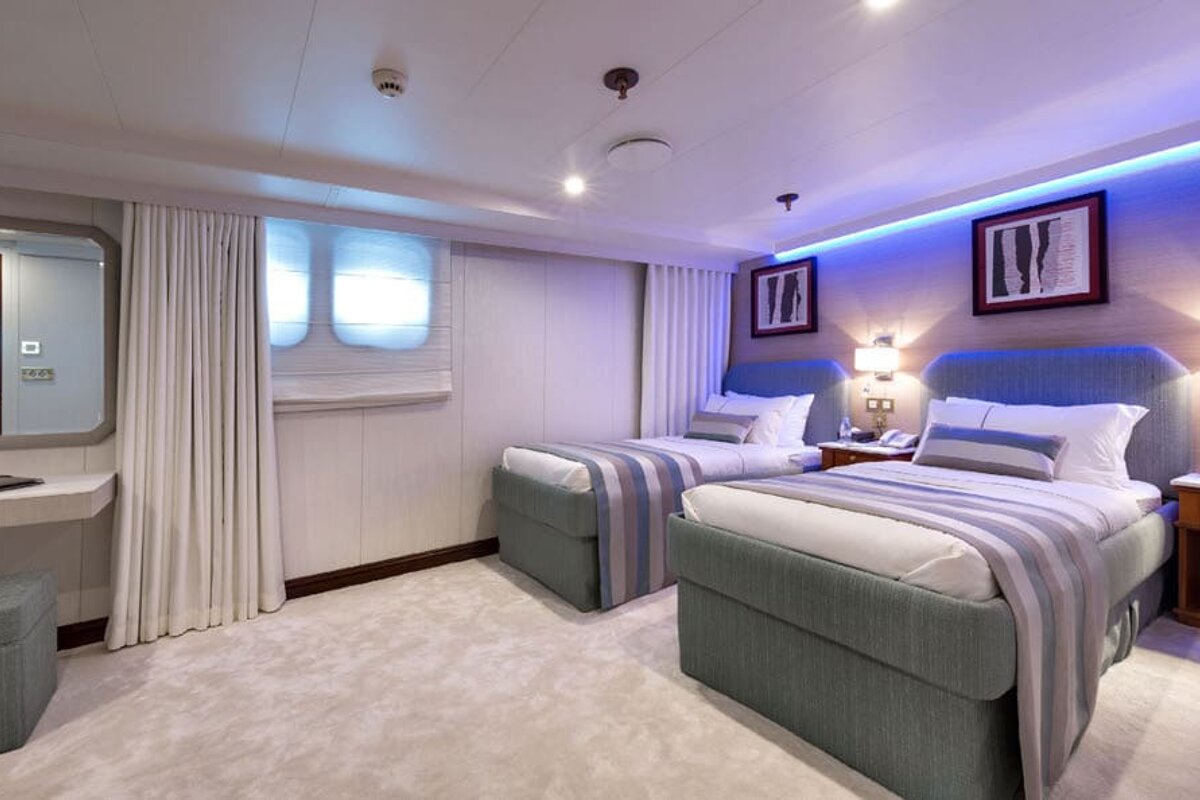 A hotel room with two beds and a mirror