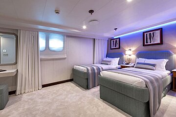 A hotel room with two beds and a mirror