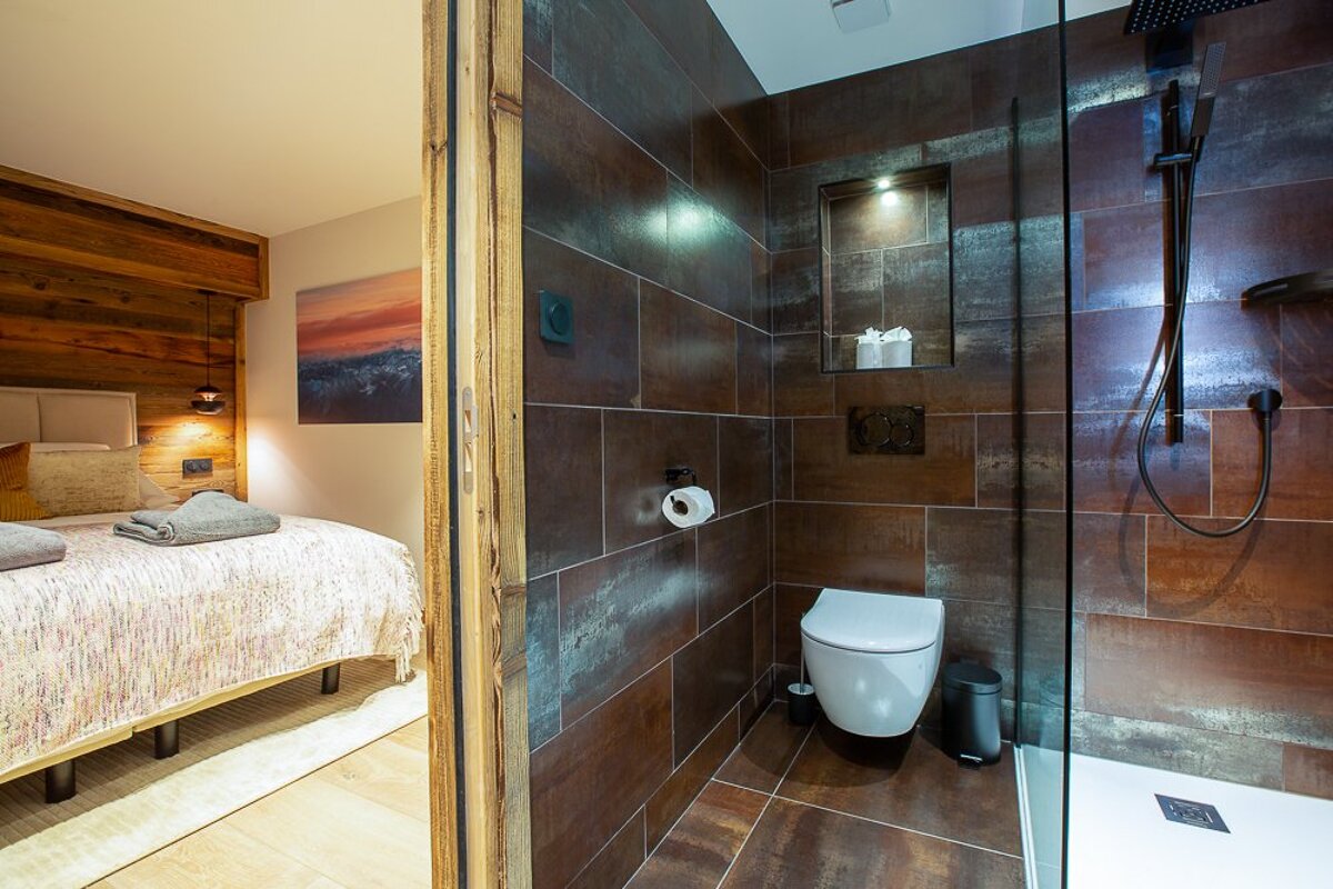 A bathroom with a toilet and a walk in shower