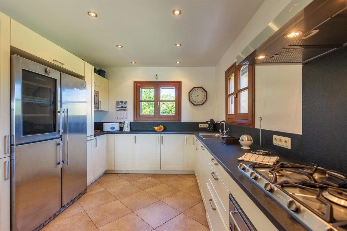 A kitchen with stainless steel appliances and a clock on the wall