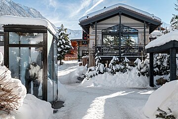 A snowy landscape with a house in the background