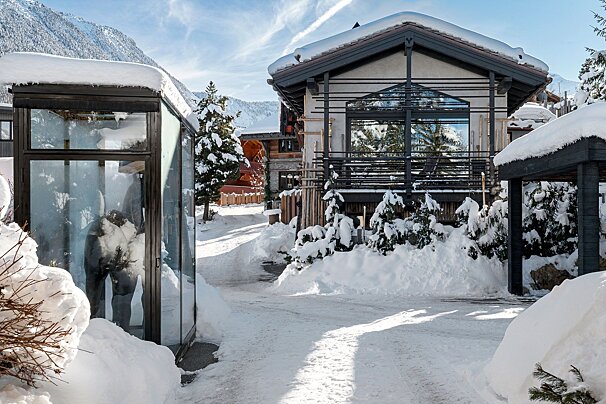 A snowy landscape with a house in the background