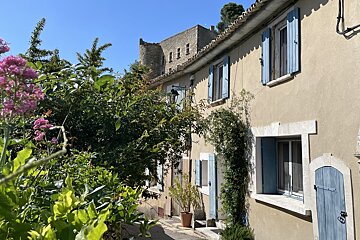 A building with blue shutters and a castle in the background