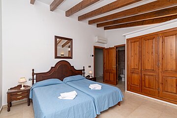 A bedroom with two beds and a mirror on the wall