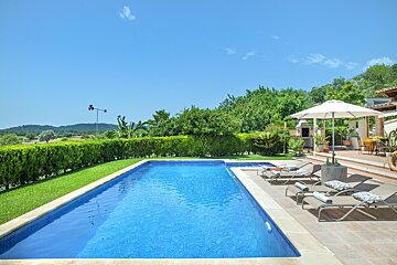 A large swimming pool surrounded by chairs and umbrellas