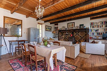 A living room with a table and chairs and a fireplace