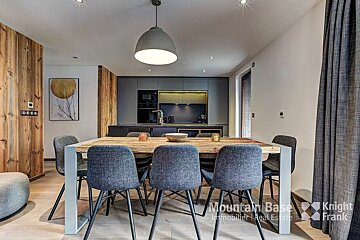 A dining room with a table and chairs from mountain base