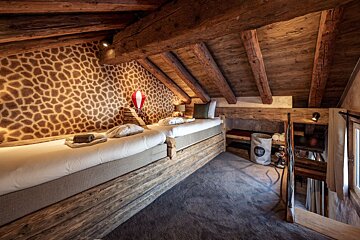 A bedroom with a giraffe print wall and two beds