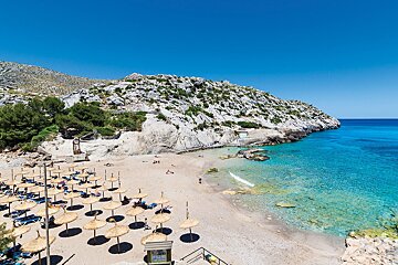A beach with lots of umbrellas and chairs