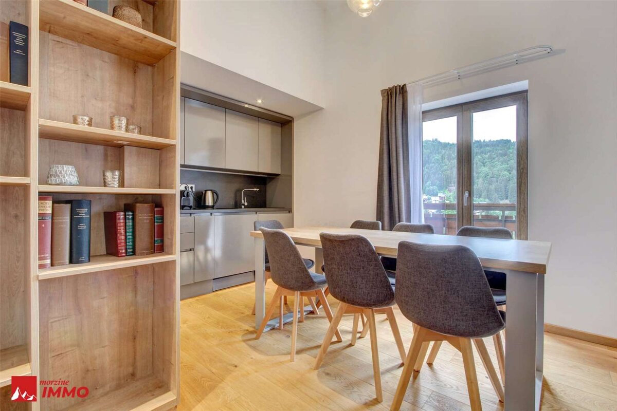 A room with a table and chairs and the word immo on the bottom