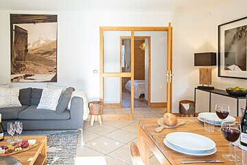 A living room with a gray couch and a wooden table