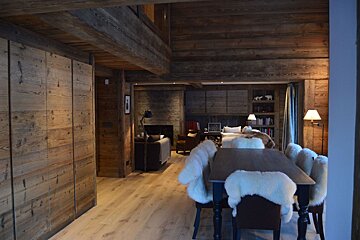 A wooden house with a dining table and chairs