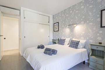 A bedroom with a floral wallpaper and a bed