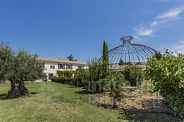 A large white house with a gazebo in front of it