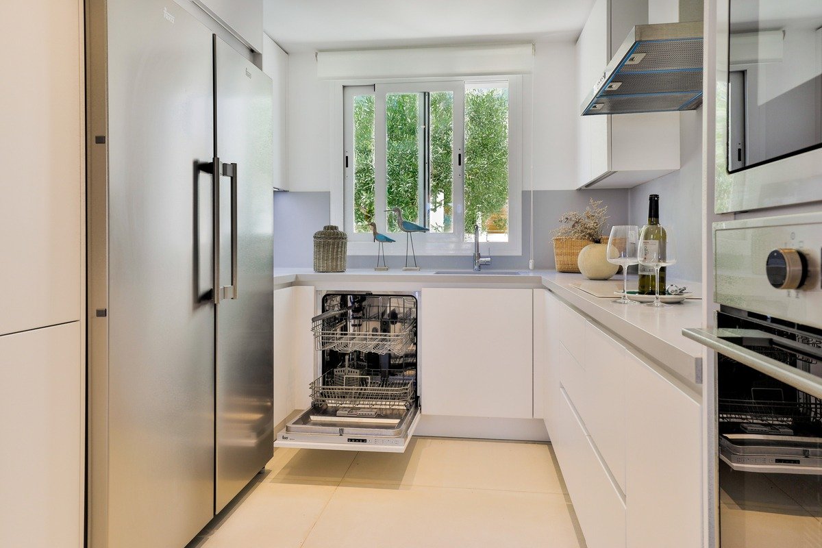 A kitchen with stainless steel appliances and white cabinets