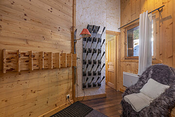A wooden room with a chair and a lamp