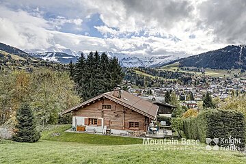 A mountain base advertisement with a house in the foreground