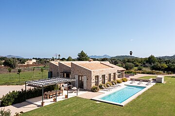 A house with a large swimming pool in front of it