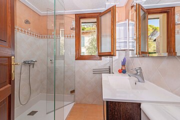 A bathroom with a walk in shower and a sink