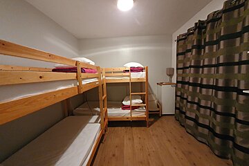 A room with bunk beds and a small refrigerator