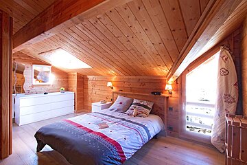 A bedroom with a bed and a dresser