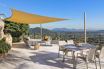 A patio with a table and chairs under a canopy