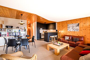 A living room with a couch a table and chairs