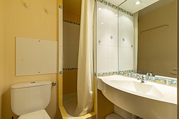 A bathroom with a toilet a sink and a mirror