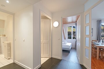A hallway leading to a dining room and a bedroom