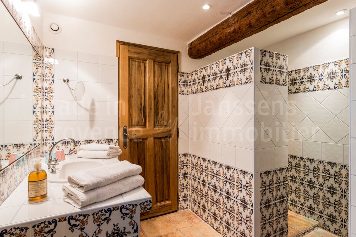 A bathroom with a wooden door and a sign that says janssens immobilier
