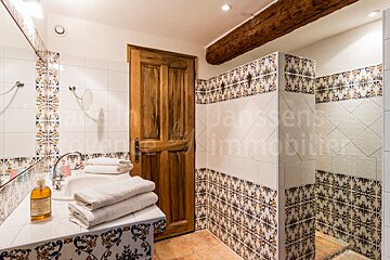 A bathroom with a wooden door and a sign that says janssens immobilier