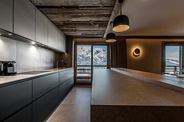 A kitchen with black cabinets and a nespresso machine
