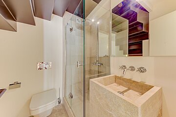 A bathroom with a toilet a sink and a shower