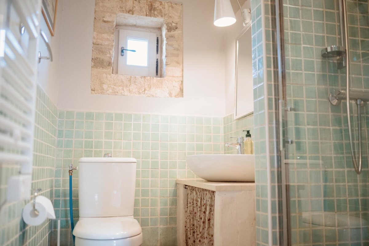 A bathroom with a toilet a sink and a window