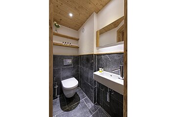 A bathroom with a toilet a sink and a mirror