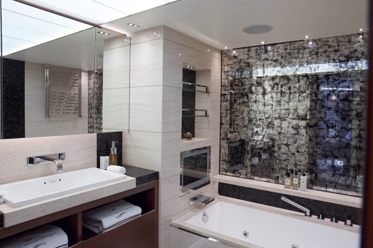 A bathroom with a tub a sink and a mirror