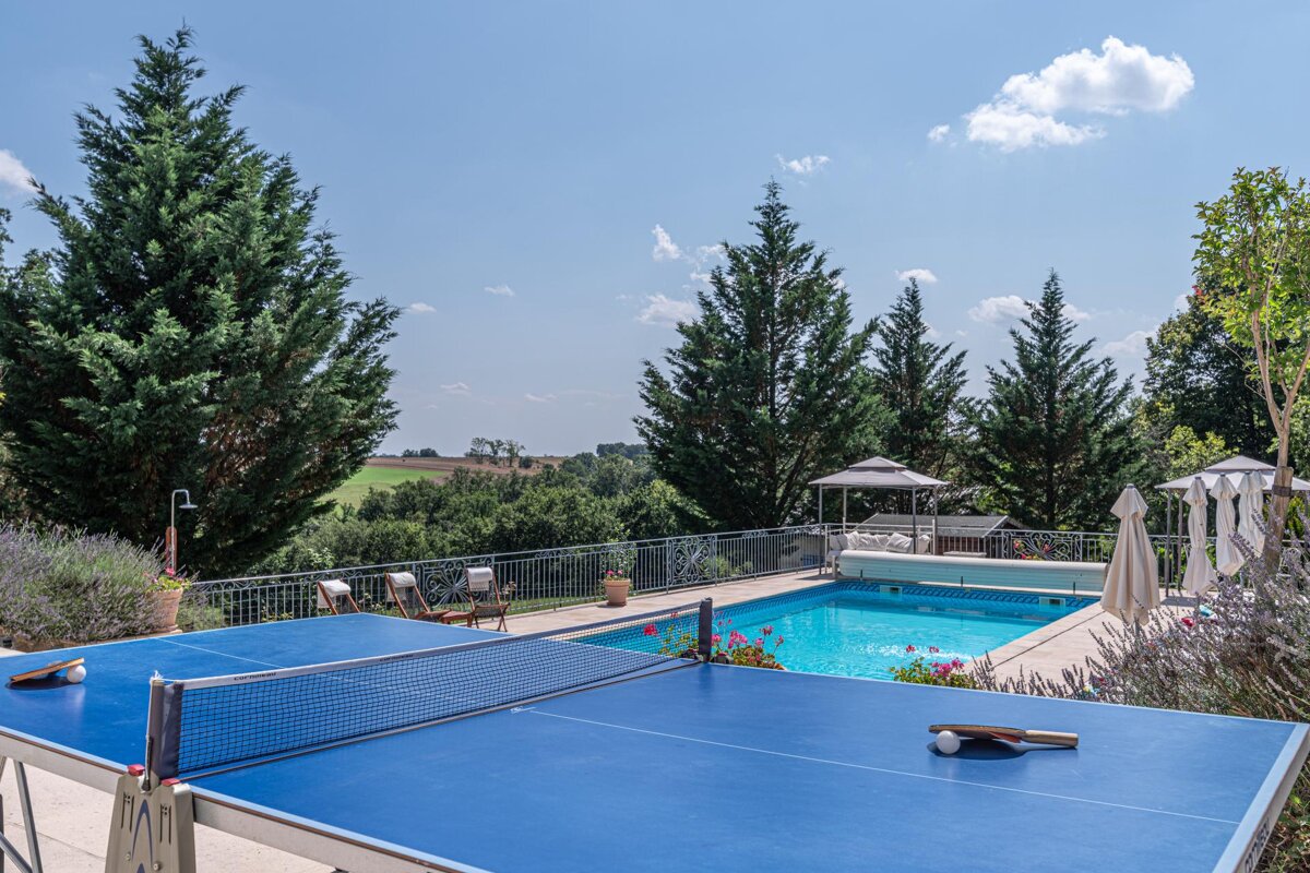 A ping pong table in front of a swimming pool