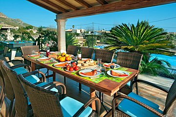 A table with plates of food and a bottle of wine on it