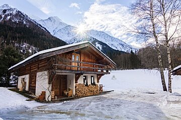 A snowy cabin with a mountain in the background