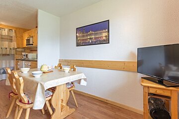A picture of a building hangs above a dining table