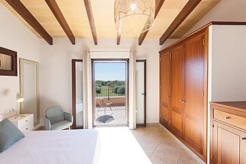 A bedroom with a sliding glass door leading to a balcony
