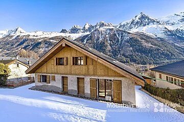 A house with mountains in the background is for sale by mountain base immobilier real estate