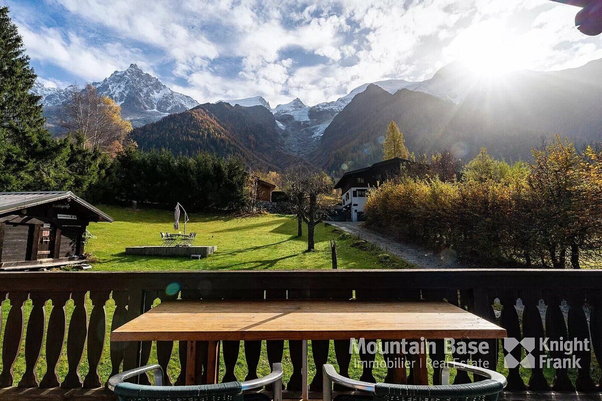 A balcony with a table and chairs and the words mountain base on it