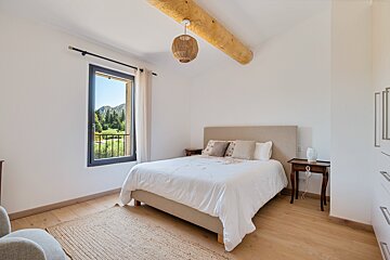 A bedroom with a large bed and a window