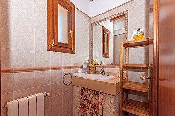A bathroom with a sink a mirror and a shelf