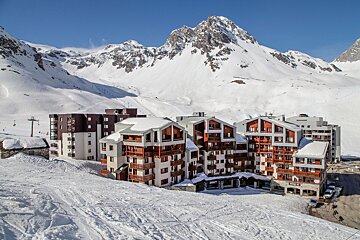 A ski resort with a mountain in the background and a building that says ' hotel ' on it