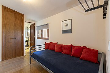 A bed with red pillows and a picture on the wall above it